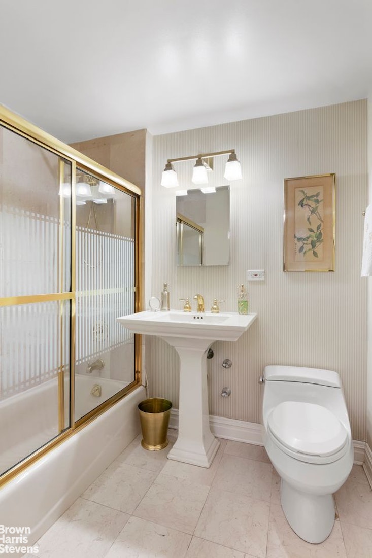 110 East 57th Street, Unit 4FG Manhattan, NY 10022 - Photo 7 of 9 a bathroom with a sink toilet and shower