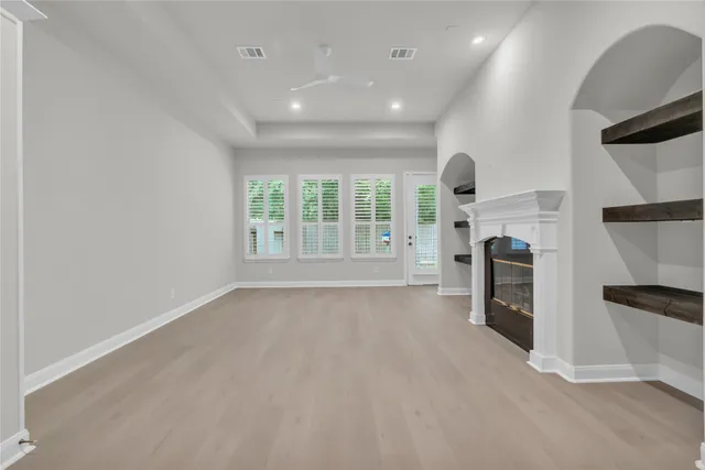 an empty room with fireplace and windows