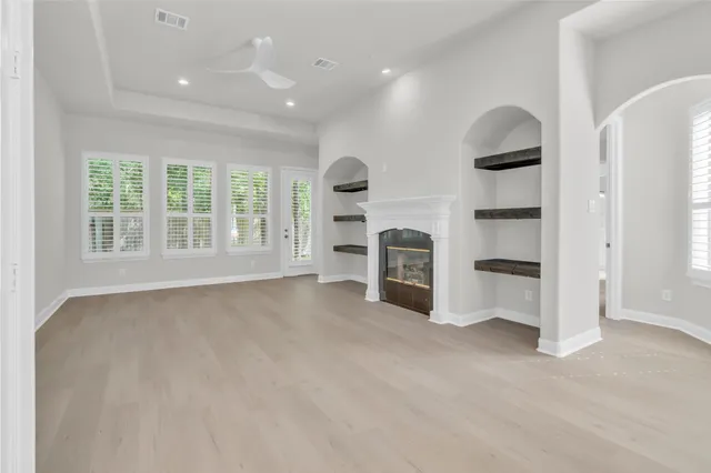 an empty room with windows and cabinet