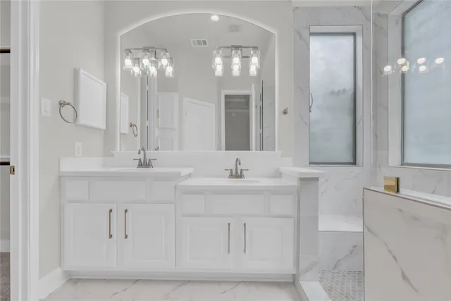a bathroom with double vanity and a mirror