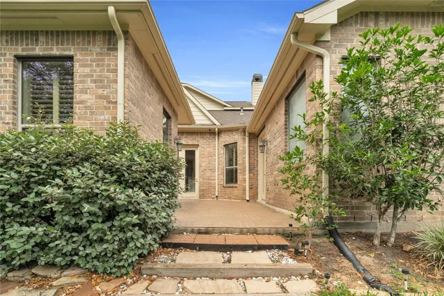 a view of a white house with a large windows and flower plants