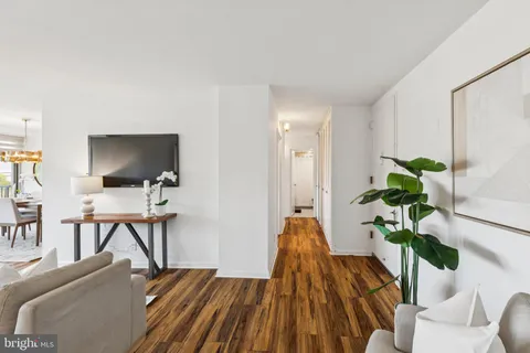 a living room with furniture a flat screen tv and a potted plant