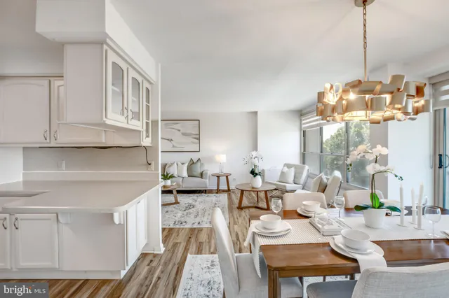 a living room with furniture a chandelier and a dining table