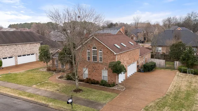 a front view of a house with a garden and trees