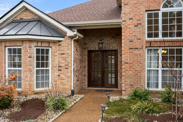 a view of an empty room with wooden floor and a ceiling fan