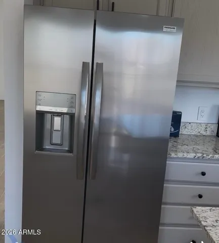 a view of a refrigerator in kitchen and wooden floor