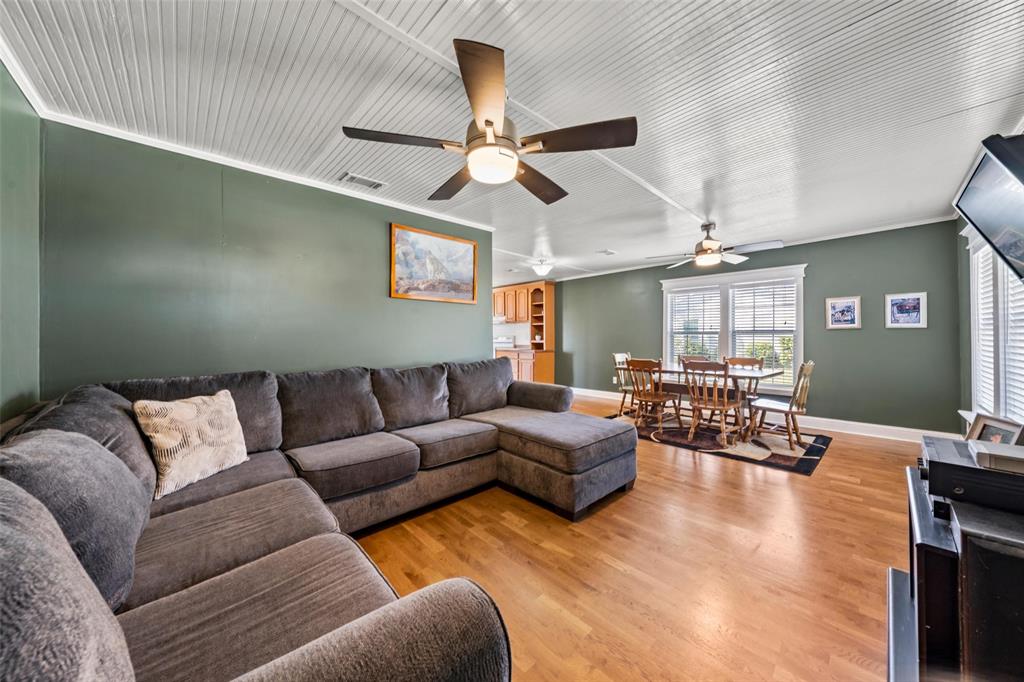 710 South Old Temple Road Lorena, TX 76655 - Photo 2 of 19 Living area with ornamental molding, wood finished floors, and a ceiling fan