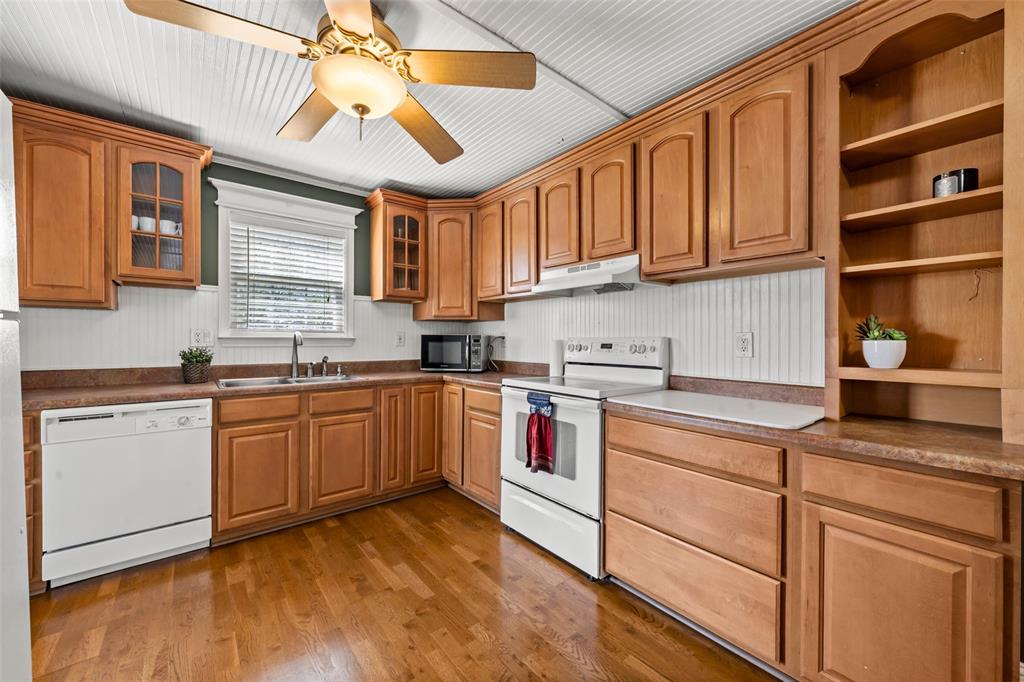 710 South Old Temple Road Lorena, TX 76655 - Photo 6 of 19 Kitchen featuring open shelves, white appliances, glass fronted cabinets, dark wood-style floors, and a ceiling fan