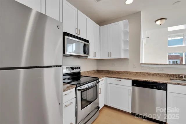 a kitchen with white cabinets stainless steel appliances and sink