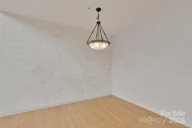 a view of a room with wooden floor and a ceiling fan