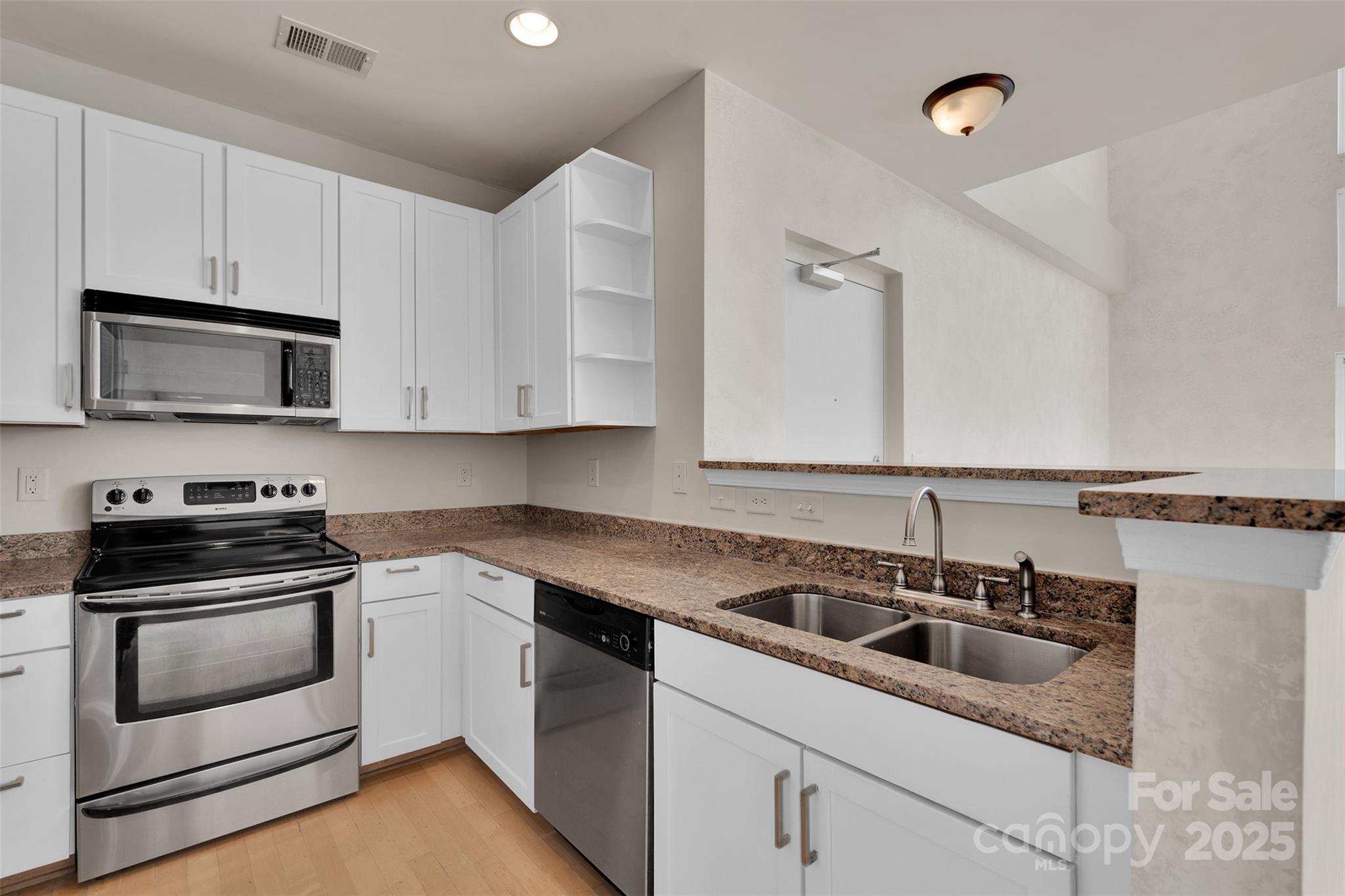 649 Raphael Place Charlotte, NC 28205 - Photo 10 of 47 a kitchen with stainless steel appliances granite countertop white cabinets a sink and dishwasher a stove with wooden floor
