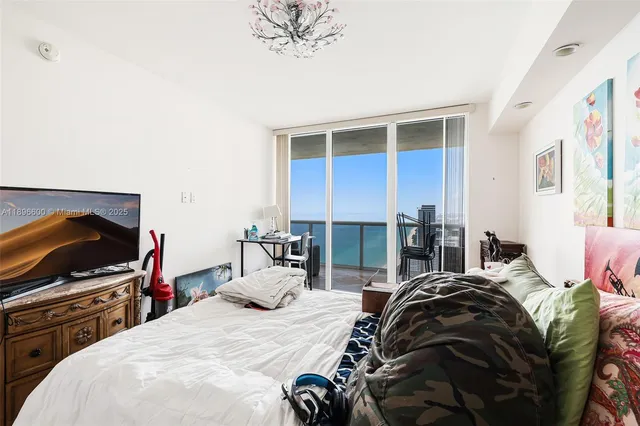 a bedroom with a bed and a chandelier