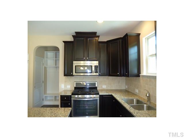 813 Wickham Ridge Road Apex, NC 27539 - Photo 4 of 25 Beautiful maple cabinets with crown, stainless steel, granite tops, island and hardwoods floors.