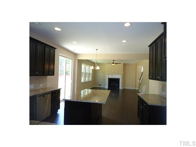 813 Wickham Ridge Road Apex, NC 27539 - Photo 6 of 25 Kitchen opens into the family room! Hardwood floors, recessed lights, 9 ft ceilings and lots of windows.