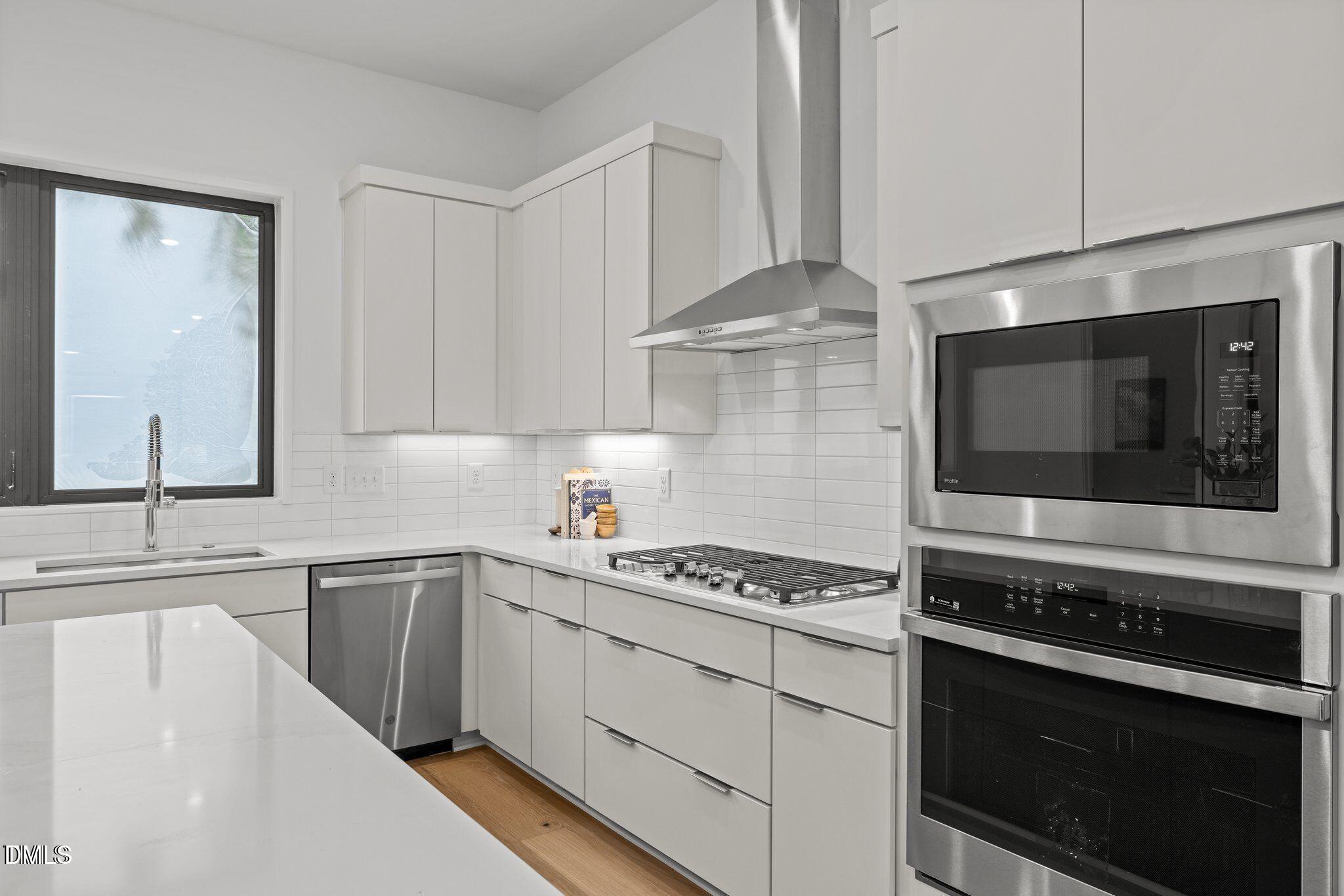516 Edgecreek Court Raleigh, NC 27604 - Photo 15 of 26 a kitchen with stainless steel appliances a stove microwave and cabinets