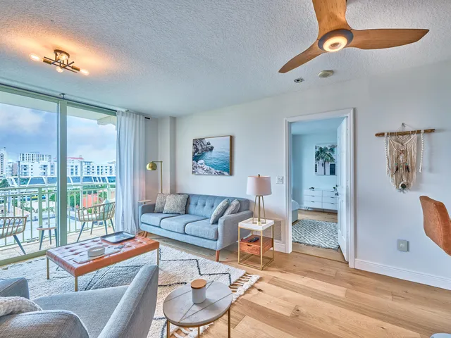 a living room with furniture a rug and a floor to ceiling window
