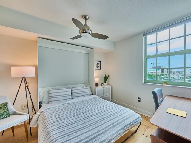 a bedroom with a bed and wooden floor
