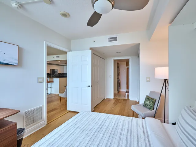 a view of a hallway with wooden floor and closet area