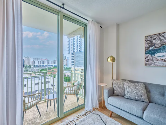 a living room with furniture and a floor to ceiling window