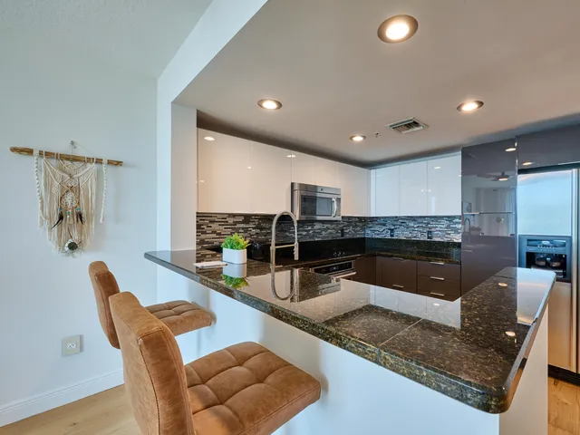 a kitchen with stainless steel appliances granite countertop a sink and a granite counter tops