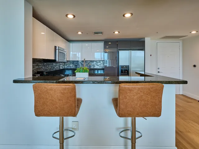a kitchen with stainless steel appliances granite countertop a stove a sink a refrigerator and a refrigerator