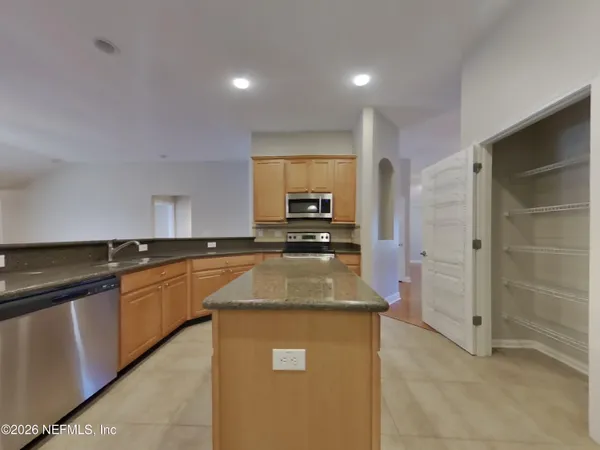 a kitchen with granite countertop a sink a counter top space and cabinets