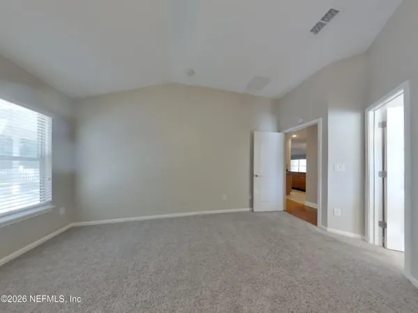 an empty room with windows and closet