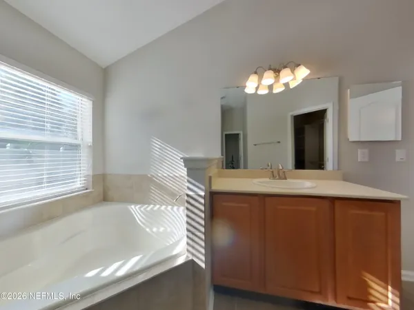 a bathroom with a tub sink and a mirror