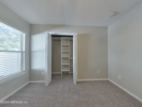 an empty room with windows and closet