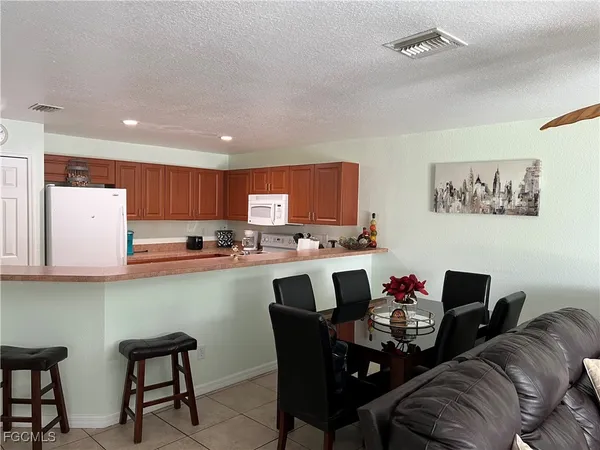 a dining room with furniture and kitchen view