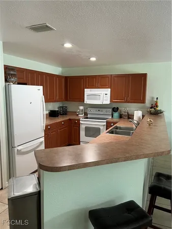 a kitchen with stainless steel appliances granite countertop a refrigerator a stove a sink dishwasher and a refrigerator