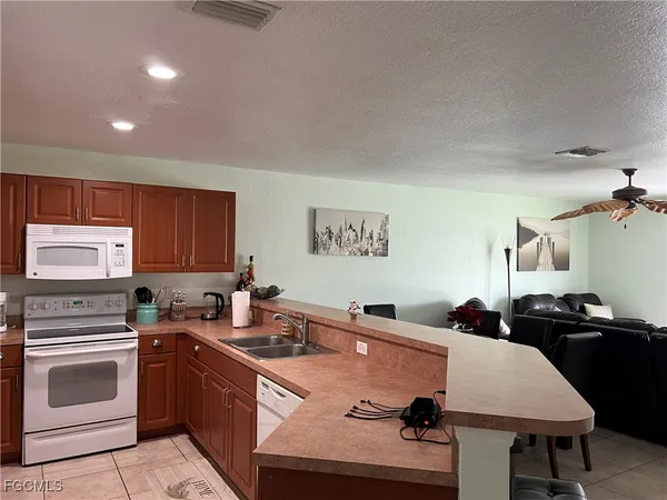 a kitchen with granite countertop a sink stainless steel appliances and cabinets