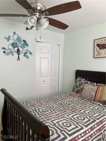 a bedroom with a bed and a potted plant on the dresser