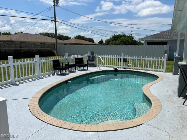 a view of a swimming pool with a patio and a garden