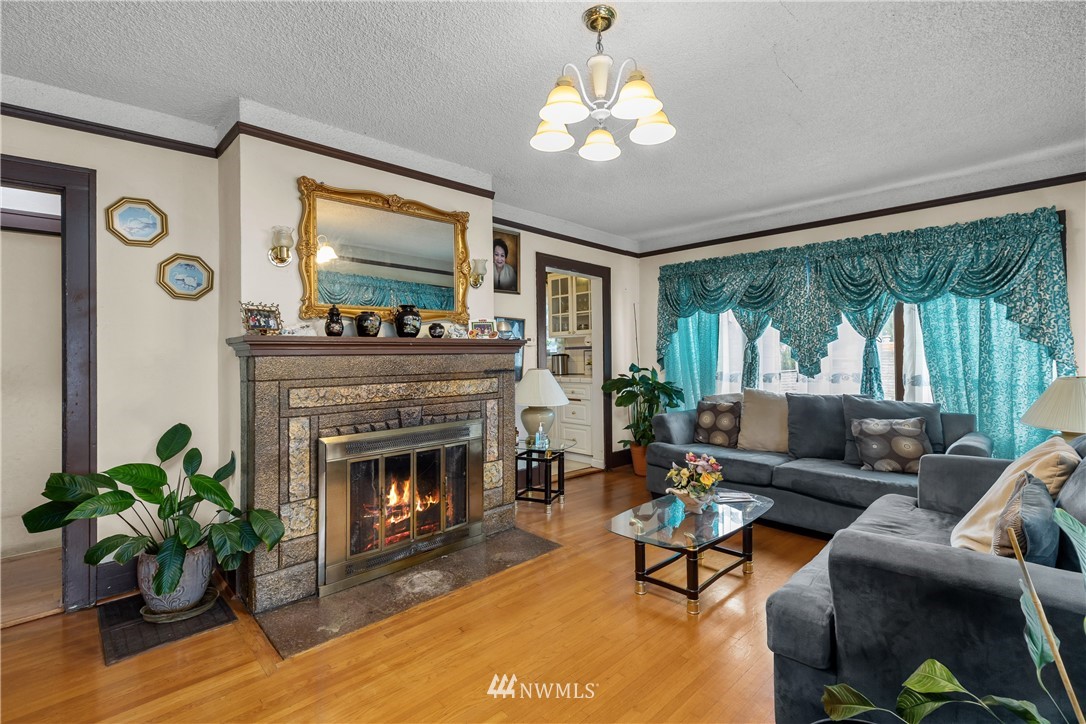 5069 Renton Avenue South Seattle, WA 98118 - Photo 10 of 40 a living room with furniture a chandelier and a fireplace