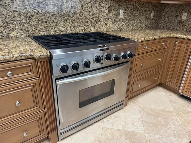 a kitchen with stainless steel appliances granite countertop a sink stove and refrigerator