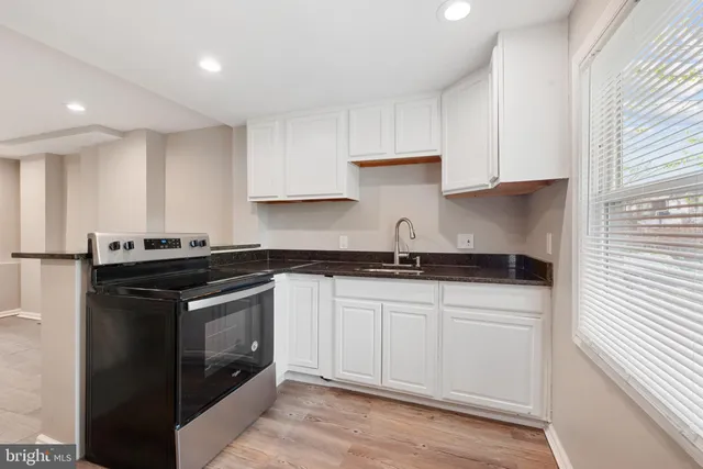 a kitchen with stainless steel appliances granite countertop a sink and a stove