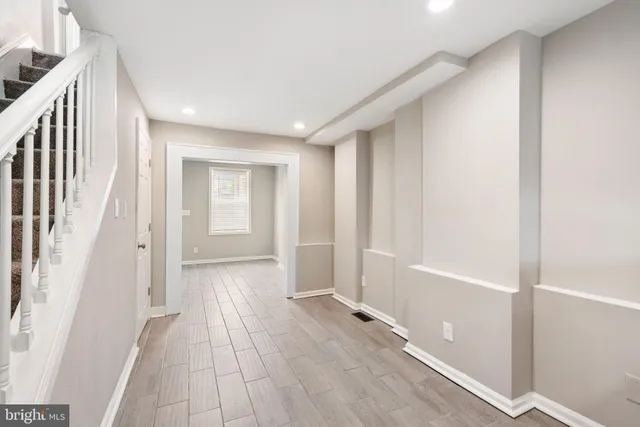 a view of a hallway with wooden floor and staircase