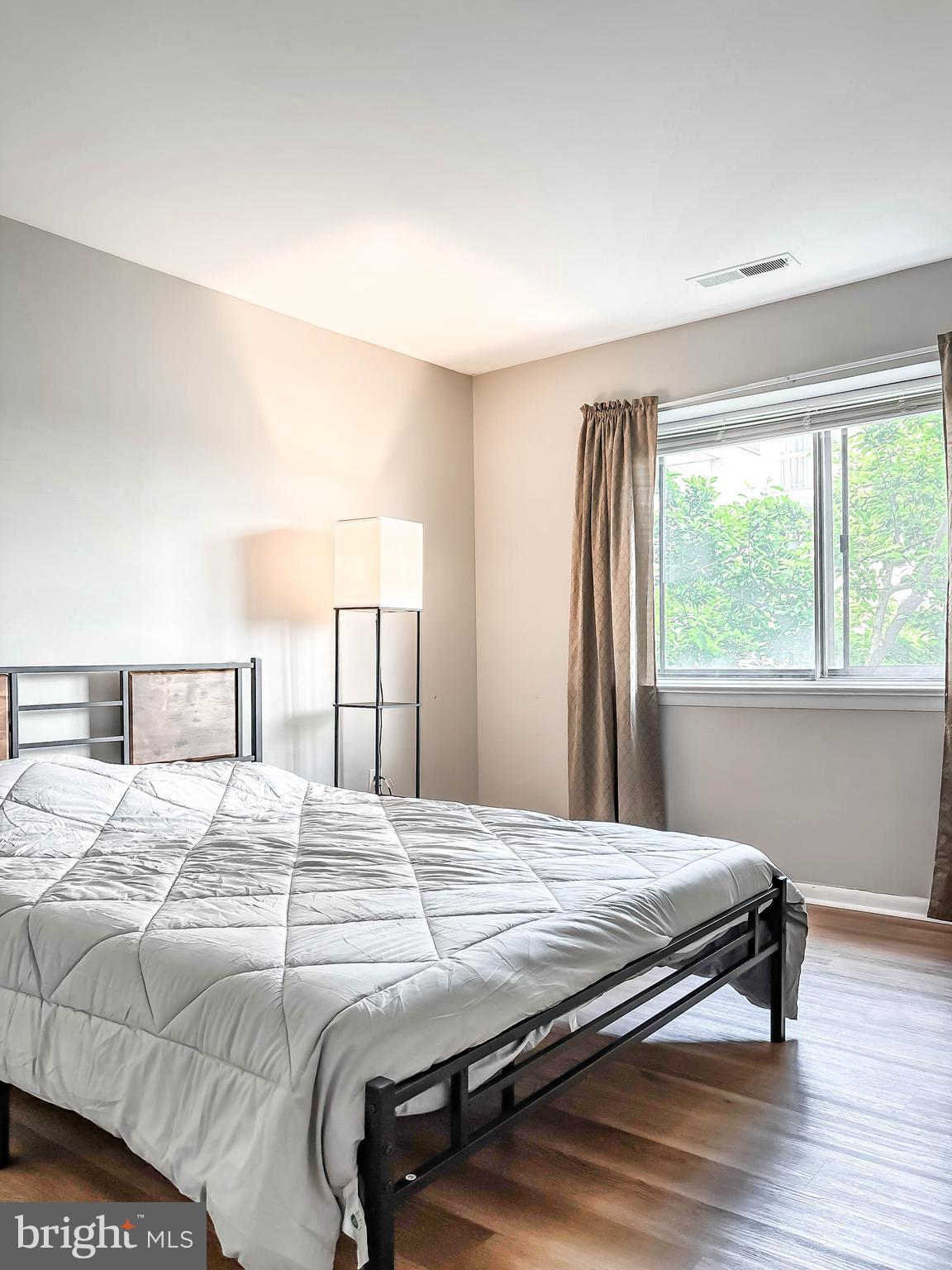 130 Slade Avenue, Unit 414 Baltimore, MD 21208 - Photo 22 of 48 a bedroom with a bed and a large window