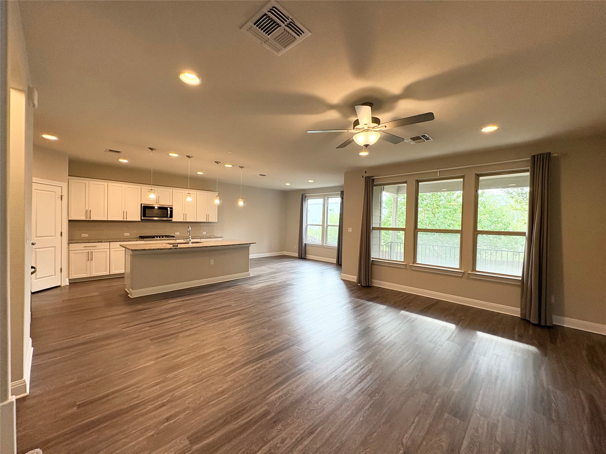 16103 Windroot Street Austin, TX 78728 - Photo 32 of 32 An open floor plan seamlessly connects the kitchen and living areas over rich wood-look flooring.