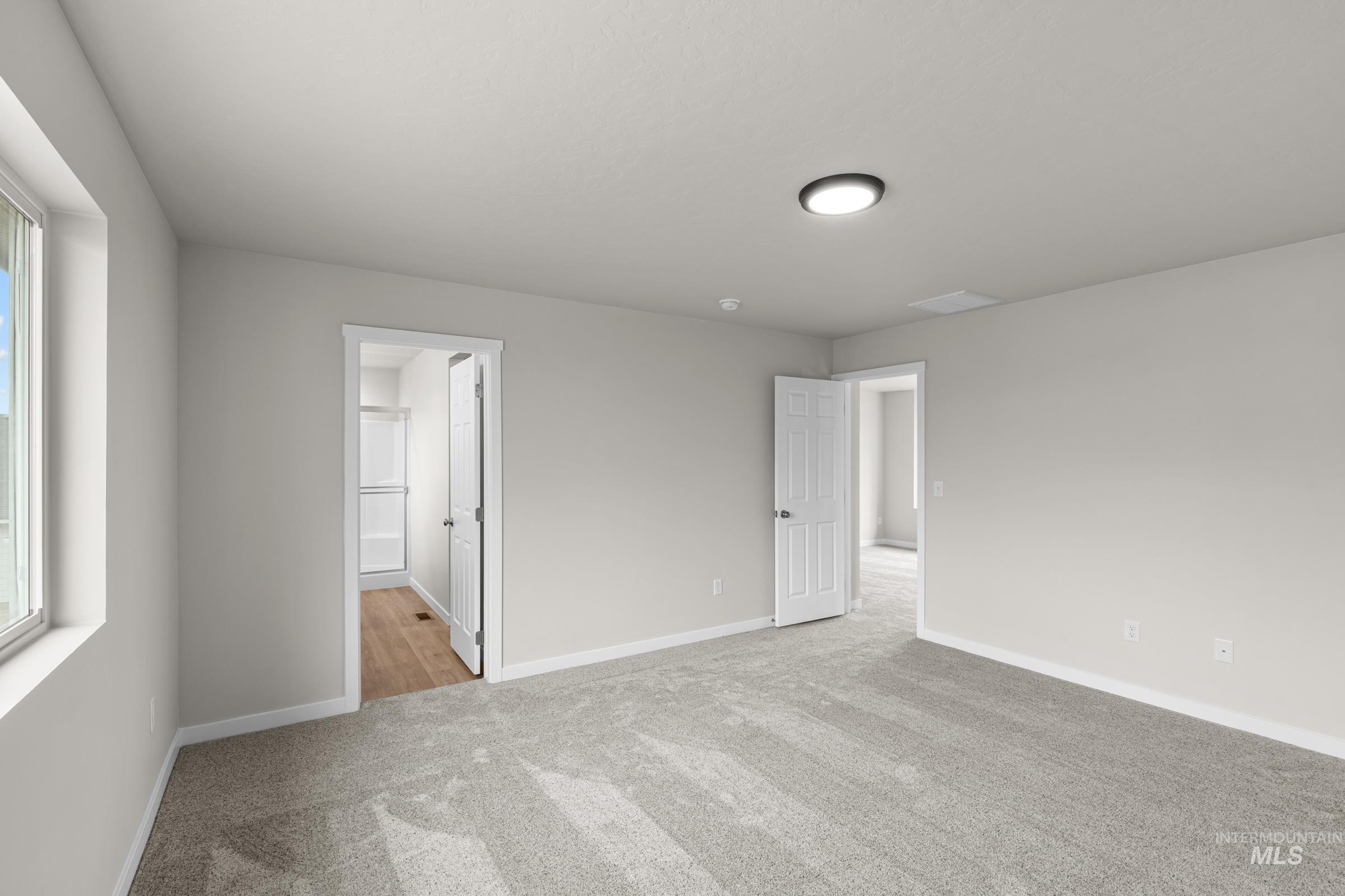 503 Hamlow Avenue Middleton, ID 83644 - Photo 17 of 21 Unfurnished bedroom with light carpet, ensuite bathroom, and multiple windows