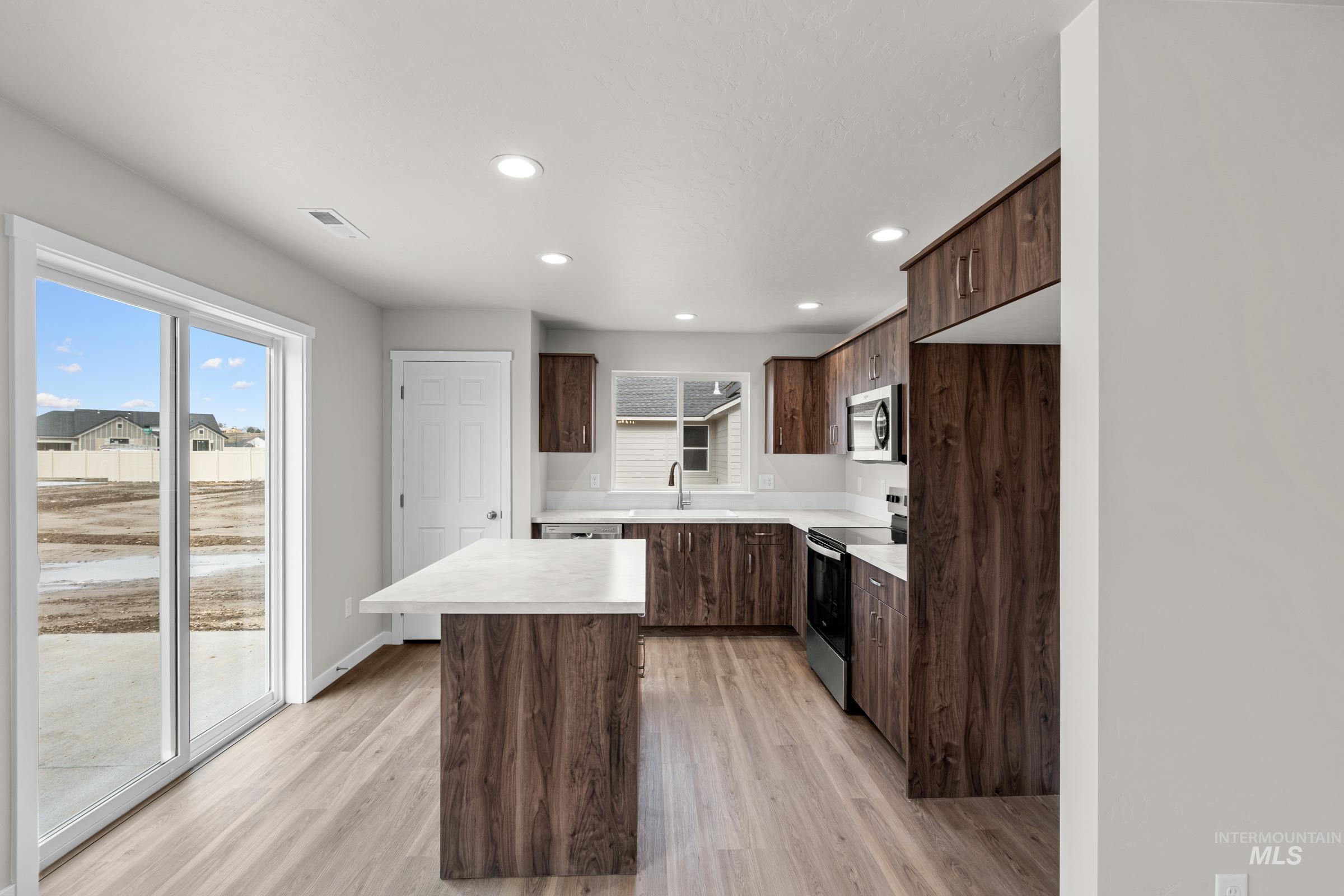 503 Hamlow Avenue Middleton, ID 83644 - Photo 3 of 21 Kitchen featuring light countertops, stainless steel appliances, recessed lighting, a kitchen island, and dark wood finish cabinetry