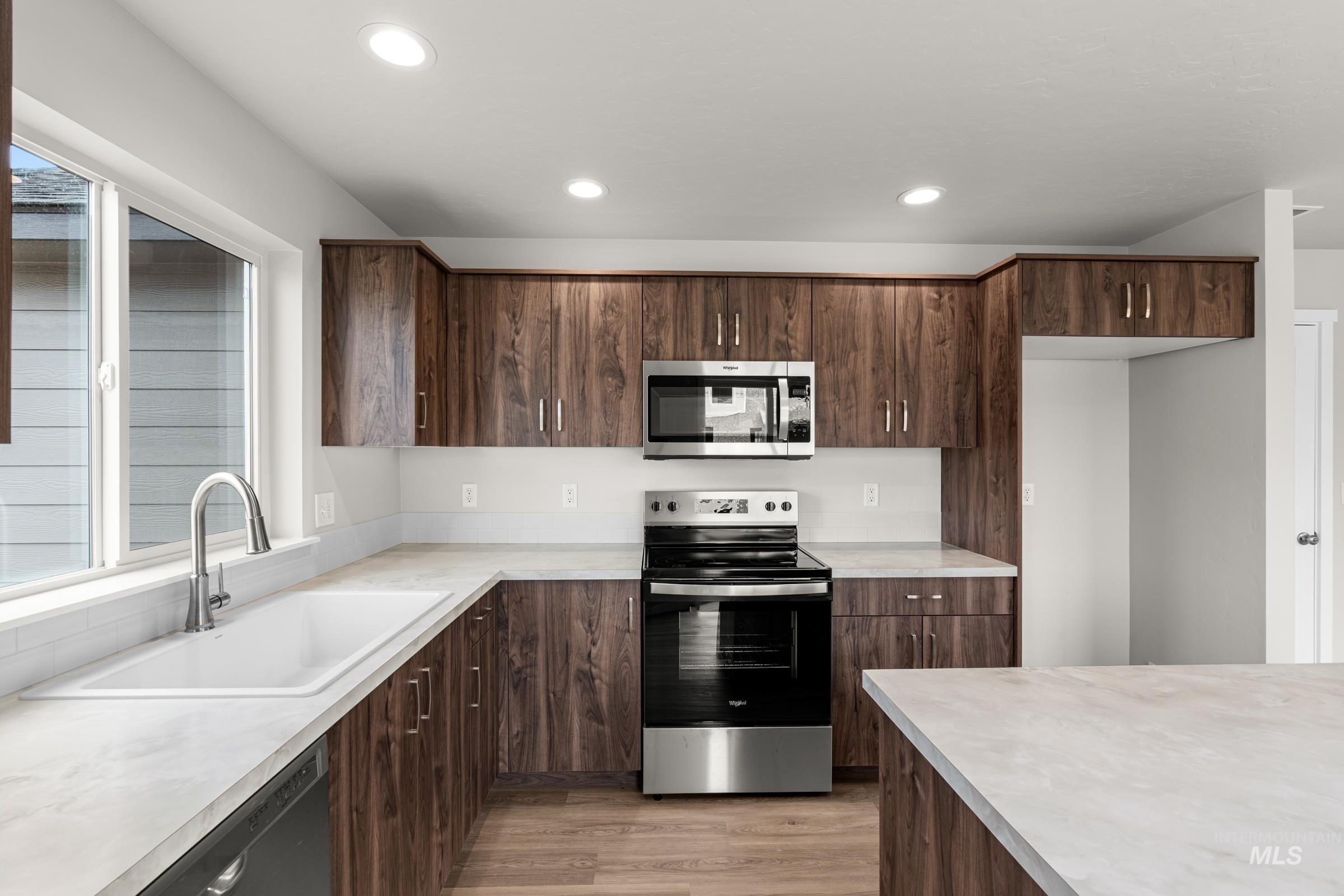 503 Hamlow Avenue Middleton, ID 83644 - Photo 5 of 21 Kitchen with stainless steel appliances, light countertops, dark wood finish cabinets, light wood-style floors, and recessed lighting