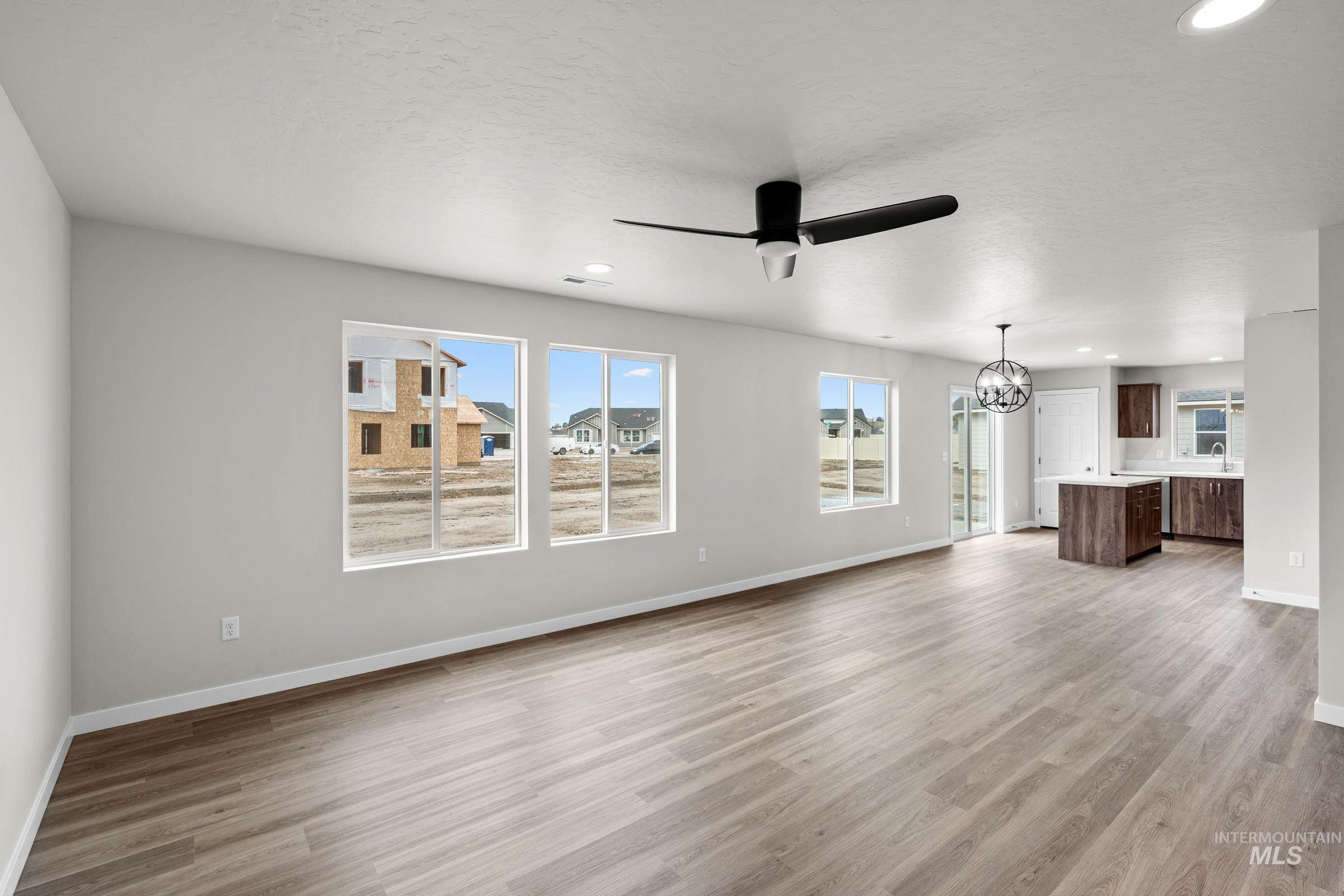 503 Hamlow Avenue Middleton, ID 83644 - Photo 8 of 21 Unfurnished living room featuring hanging lights, ceiling fan, and light wood-style flooring