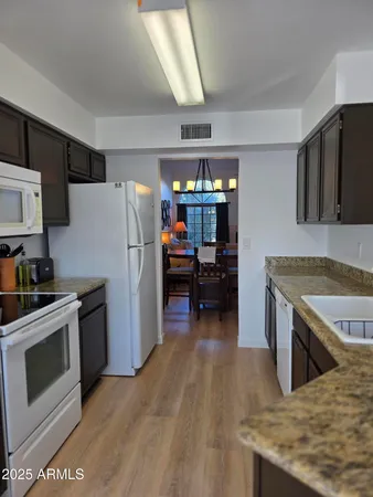a bedroom with a bed lamps and wooden floor