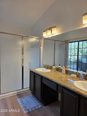 a bathroom with a granite countertop sink and a mirror