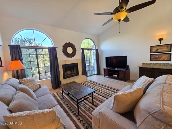 a living room with furniture a fireplace and a flat screen tv