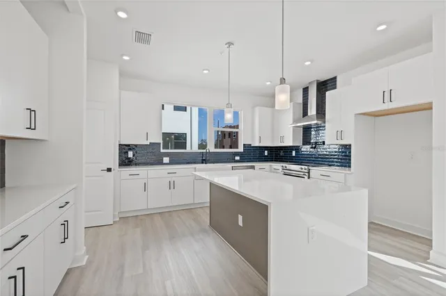 a kitchen with stainless steel appliances sink a stove and cabinets
