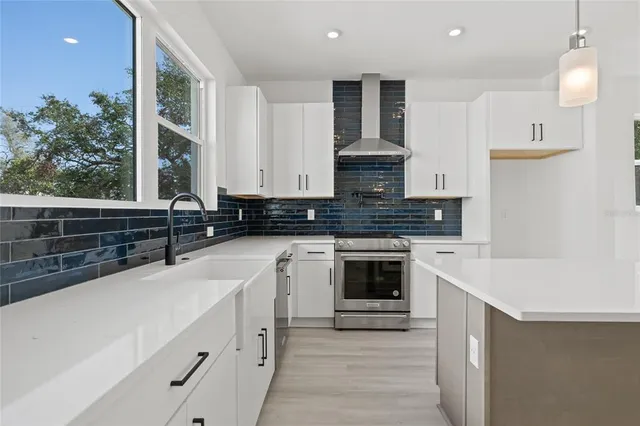 a kitchen with stainless steel appliances granite countertop a sink a stove and a refrigerator