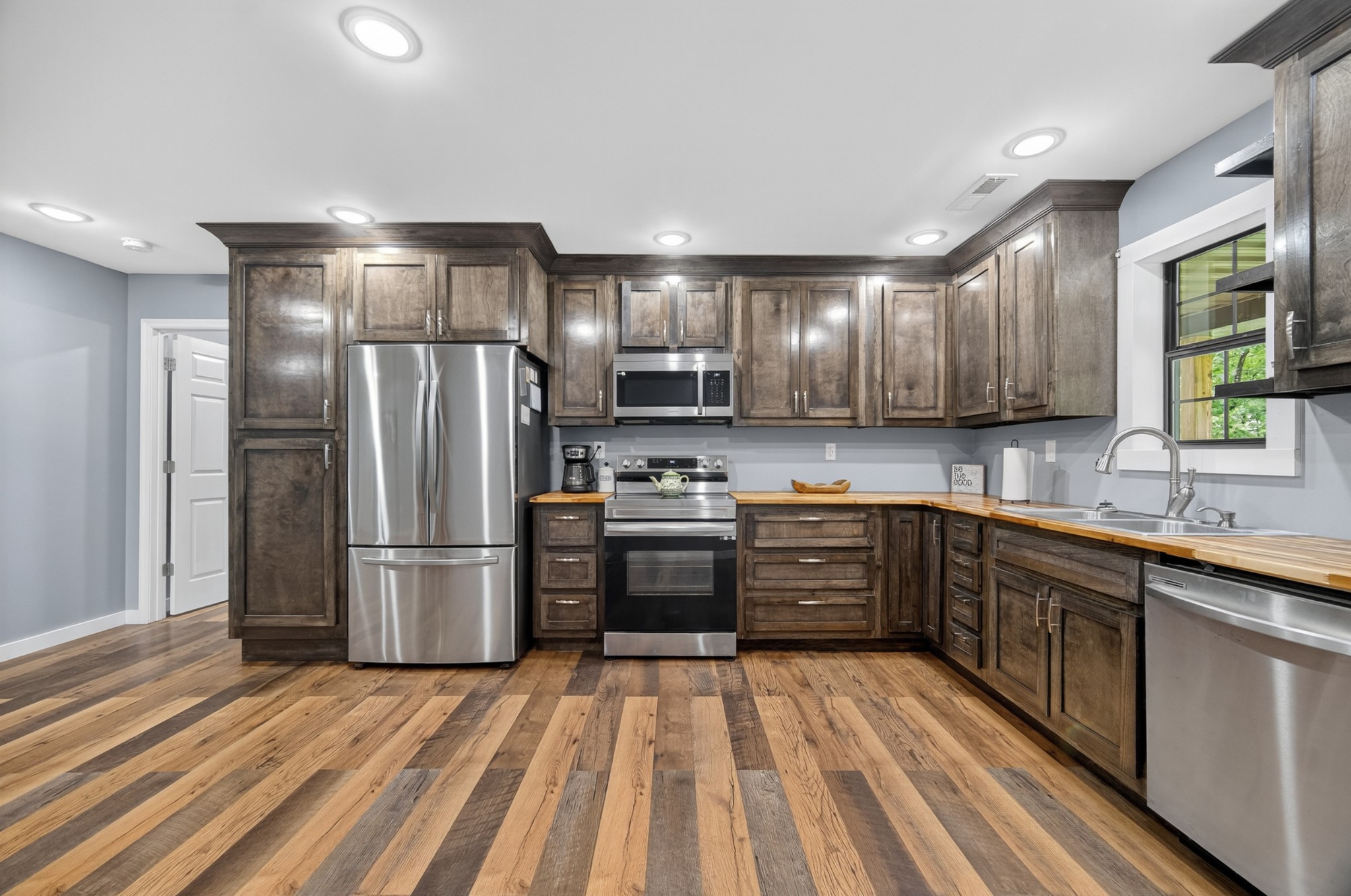 63 North King Road Flintville, TN 37335 - Photo 11 of 37 a kitchen with stainless steel appliances granite countertop a refrigerator stove a sink dishwasher and wooden cabinets with wooden floor